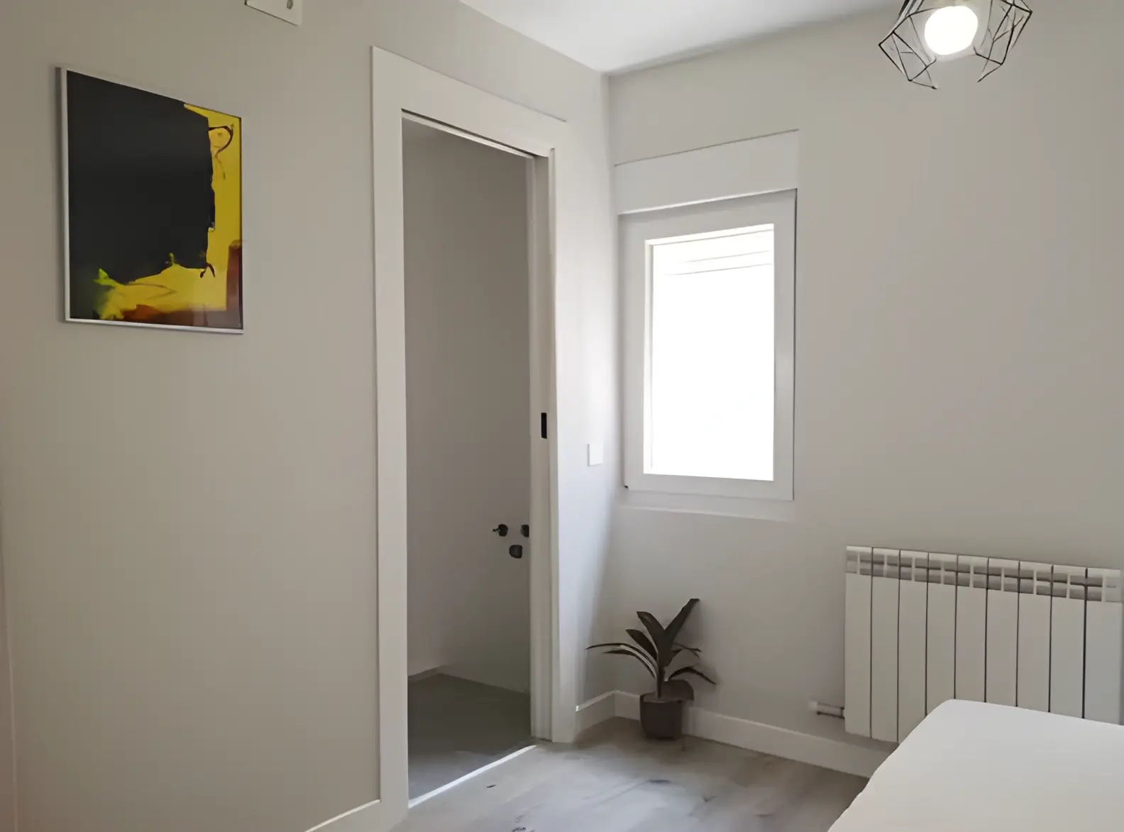 Habitación recién pintada en blanco por Los Pintores Toledo para comunidad de vecinos
